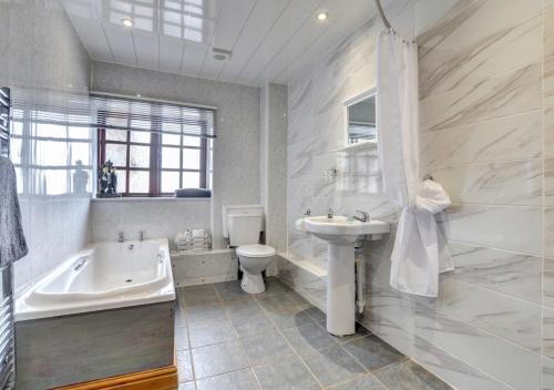 een badkamer met een bad, een wastafel en een toilet bij Yr Efail in Y Felinheli