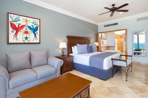 ヌエボ・バジャルタにあるVilla La Estancia Beach Resort & Spa Riviera Nayaritのベッドとソファ付きのホテルルーム