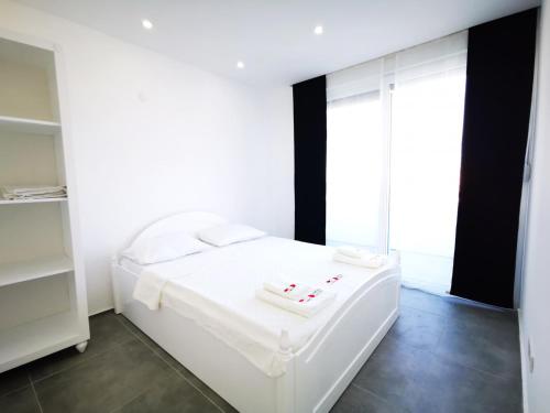 uma cama branca num quarto com uma grande janela em Spectacular Villa with Private Pool in Antalya em Belek