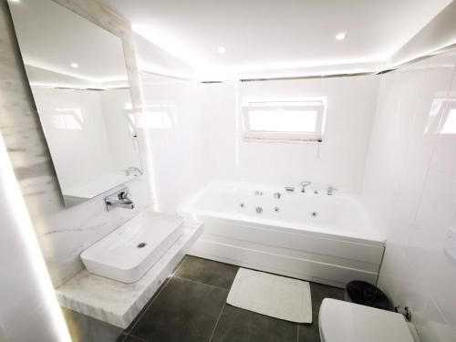 uma casa de banho branca com uma banheira e um lavatório em Spectacular Villa with Private Pool in Antalya em Belek