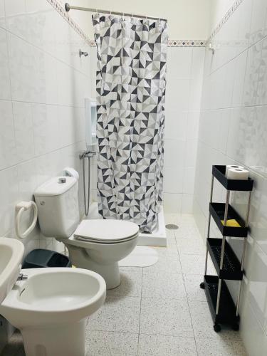 a bathroom with a toilet and a shower curtain at Apartamentos azayara in Frontera