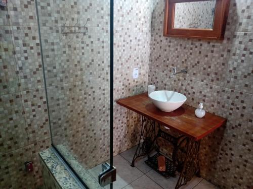 a bathroom with a sink and a glass shower at Pousada luar da serra in Lumiar