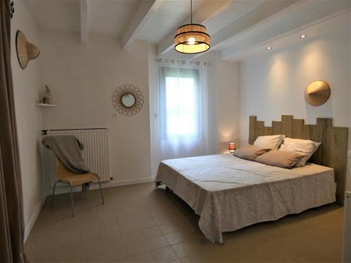 - une chambre avec un lit, une chaise et une fenêtre dans l'établissement Le petit saou du becq, à Saint-Lon-les-Mines