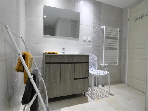 La salle de bains est pourvue d'une coiffeuse avec un lavabo et une chaise. dans l'établissement Le petit saou du becq, à Saint-Lon-les-Mines