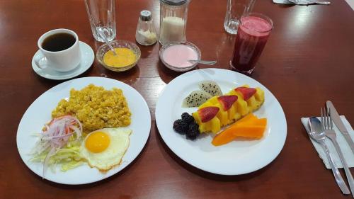 uma mesa com dois pratos de comida e uma chávena de café em Hotel Loja Bella em Loja