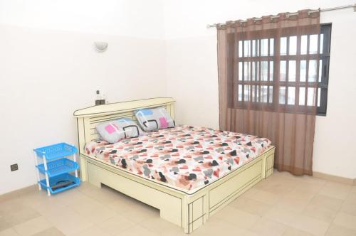 Un dormitorio con una cama con dos bolsas. en Maison Houdji, près de la lagune, en Cotonou