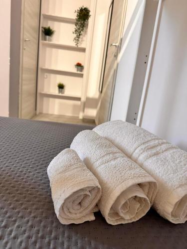 a pile of towels sitting on top of a bed at Airport Al Volo B&B in Catania