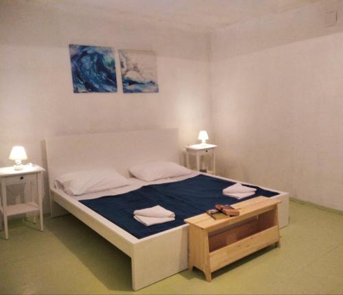 a bedroom with a large bed with a blue blanket at VillMar in Osor