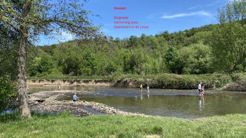 a group of people standing in the water in a river at Gites Douillets for the Family in Houyet