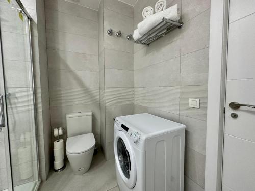 ein Badezimmer mit einer Waschmaschine und einem WC in der Unterkunft Reinapart Patacona Beach 36 in Valencia
