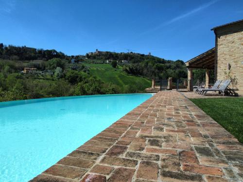 莫利亞諾的住宿－Villa Rilassati - Appartement Rilassati - infinity pool - privé terras - familie vriendelijk，一座房子旁的游泳池,设有一条砖砌小径
