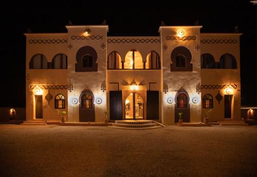a large building at night with lights on it at Riad Merzouga Dunes in Merzouga