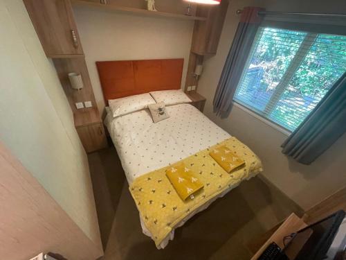a small bed in a small room with a window at Silver Birch Lodge in Auchterarder