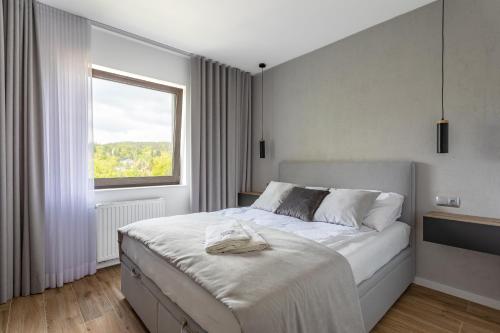ein Schlafzimmer mit einem großen weißen Bett mit einem Fenster in der Unterkunft Apartament Kryształ Górski - Stone Hill in Szklarska Poręba