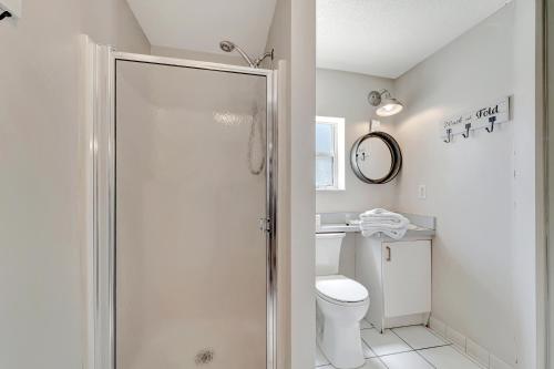 uma casa de banho branca com um chuveiro e um WC. em Ocean View Suite em Holmes Beach