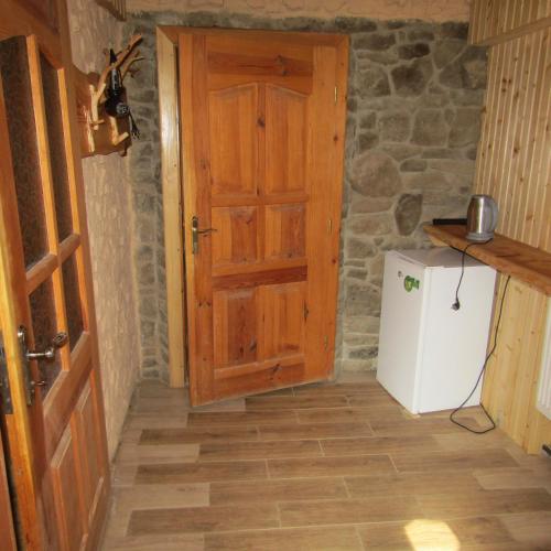 a hallway with a wooden door and a refrigerator at To Lem Ande in Lumshory