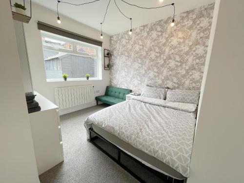 a bedroom with a bed and a green chair at Cosy Bright Studio Apartment Close to Wembley Stadium in London