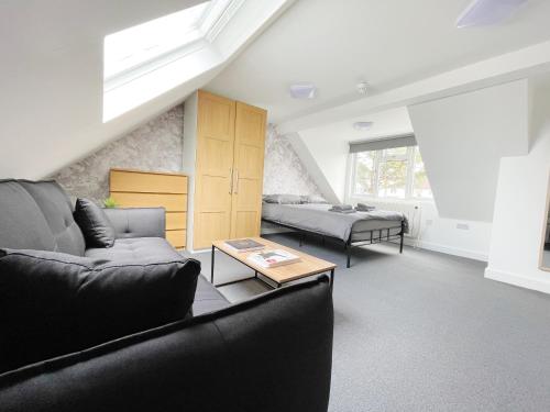 a living room with a couch and a bed at Cosy Bright Studio Apartment Close to Wembley Stadium in London