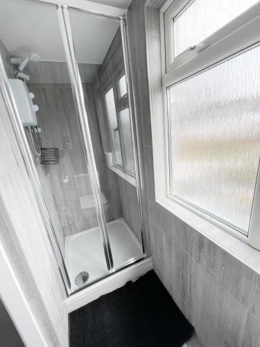 a bathroom with a shower with a window and a toilet at Cosy Bright Studio Apartment Close to Wembley Stadium in London