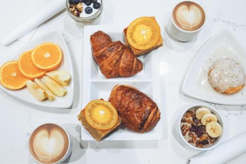 ein weißer Tisch mit Tellern mit Gebäck und Kaffee in der Unterkunft City Mills Hotel in Columbus
