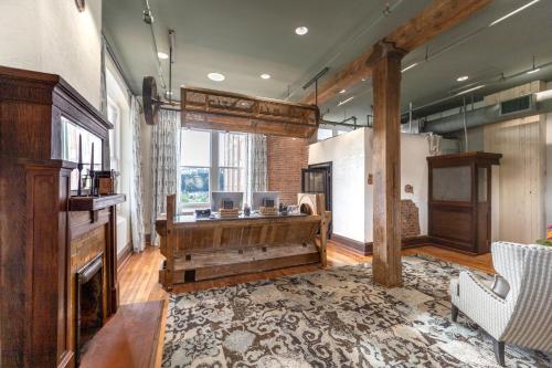 a large living room with a piano and a fireplace at City Mills Hotel in Columbus
