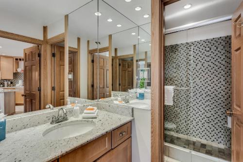 baño con 2 lavabos y espejo grande en Laurelwood Condominiums 105, en Snowmass Village