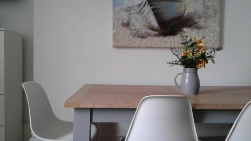 a table with chairs and a vase with flowers on it at AzZule Apartments in Tynemouth