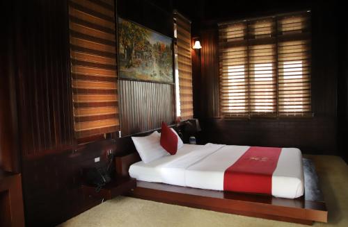 a bedroom with a white bed with a red pillow at THƯ DUY Resort in Cà Mau