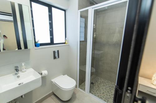 a bathroom with a shower and a toilet and a sink at 10 on Bellamare near the Beachfront in Summerstrand