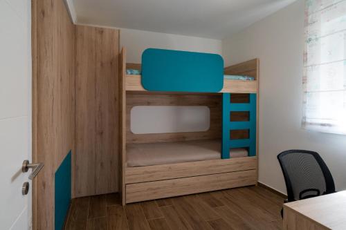 a bunk bed in a room with a desk and a chair at Nika in Brodarica