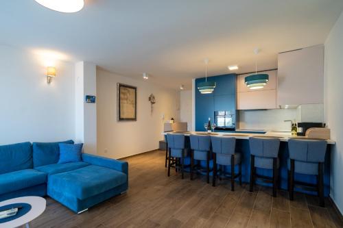 ein Wohnzimmer mit einem blauen Sofa und einer Küche in der Unterkunft Nika in Brodarica