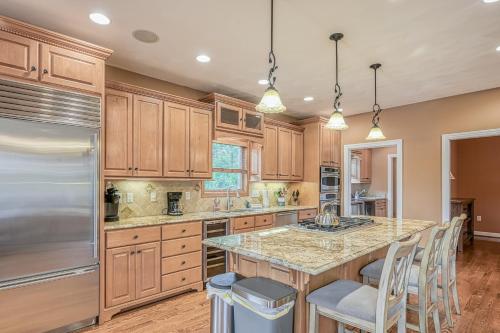 a kitchen with wooden cabinets and a large island with bar stools at Paradise at Sunset Cove in Moneta