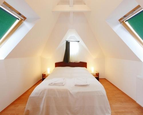 a bedroom with a bed in the attic at Centrum Apartmanház in Hévíz