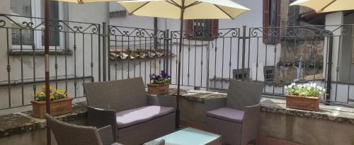 a patio with chairs and a table and an umbrella at Camere Urbevetus in Orvieto