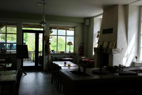 a dining room with tables and chairs and windows at Hôtel-Restaurant Le Parisien in Les Vignes