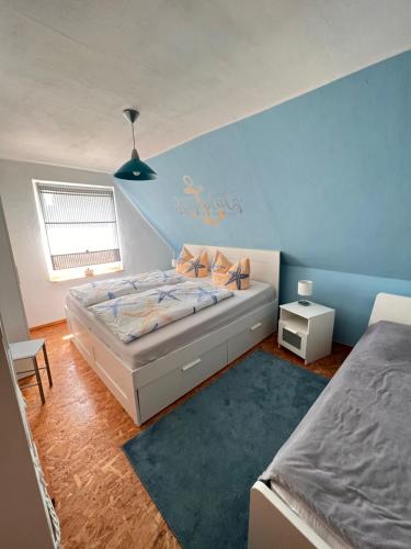 a bedroom with a bed and a blue wall at Ferienhaus Feldblick in Greifswald