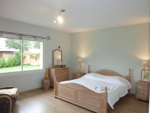 Un dormitorio con una cama grande y una ventana en Alios, en Angresse