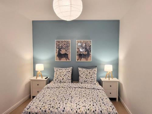 - une chambre dotée d'un lit avec 3 photos sur le mur dans l'établissement Appartement 1 Chambre, cuisine, coin salon, salle de bain, à Saint-Claude