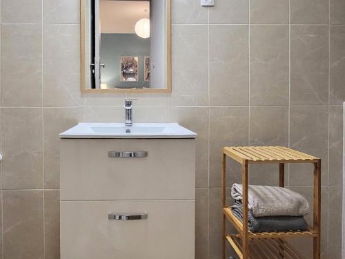 La salle de bains est pourvue d'un lavabo et d'un miroir. dans l'établissement Appartement 1 Chambre, cuisine, coin salon, salle de bain, à Saint-Claude