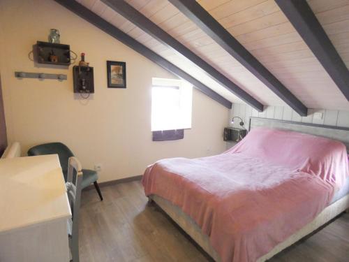 - une chambre mansardée avec un lit rose dans l'établissement Bignasse, à Saint-Vincent-de-Paul