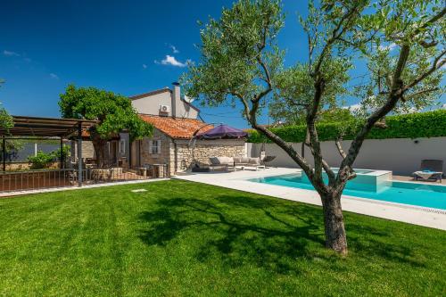 a yard with a pool and a house at Villa Mala in Umag