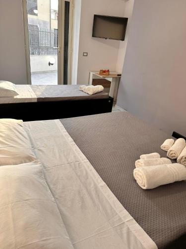 a hotel room with two beds with towels on the floor at Airport Al Volo B&B in Catania