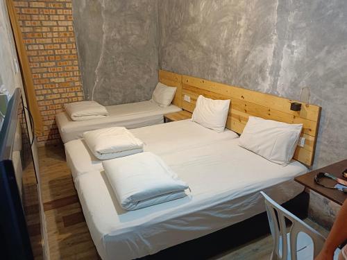 2 camas individuais num pequeno quarto com uma mesa em Myera Hotel em Banting
