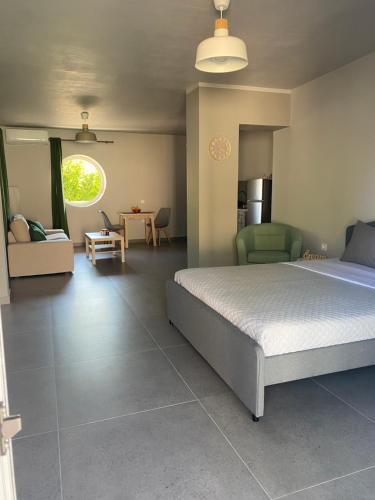 ein Schlafzimmer mit einem Bett und ein Wohnzimmer in der Unterkunft Jimmy's place in Artemida