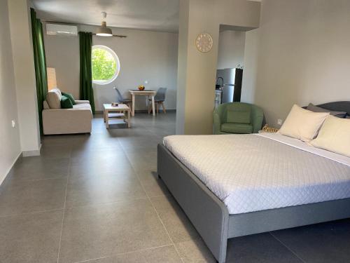 a bedroom with a bed and a living room at Jimmy's place in Artemida