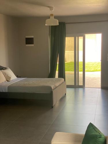 a bedroom with a bed and a sliding glass door at Jimmy's place in Artemida