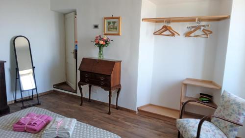 a room with a dresser and a vase of flowers on a table at Borgo 63 Medieval House in Montecelio
