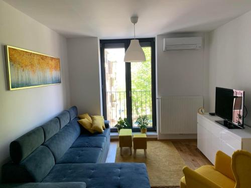 een woonkamer met een blauwe bank en een tv bij APARTMA KOPER ZVER in Koper