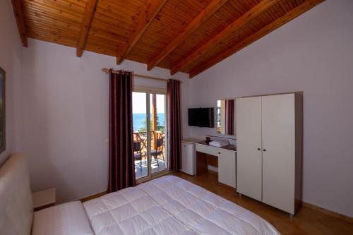 a bedroom with a bed and a sliding glass door at Hotel Olympia Touristic Village in Vlorë