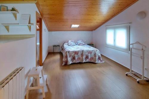 奧洛特的住宿－Precioso apartamento duplex en el centro de Olot，一间设有一张床铺的卧室,位于一个拥有木制天花板的房间